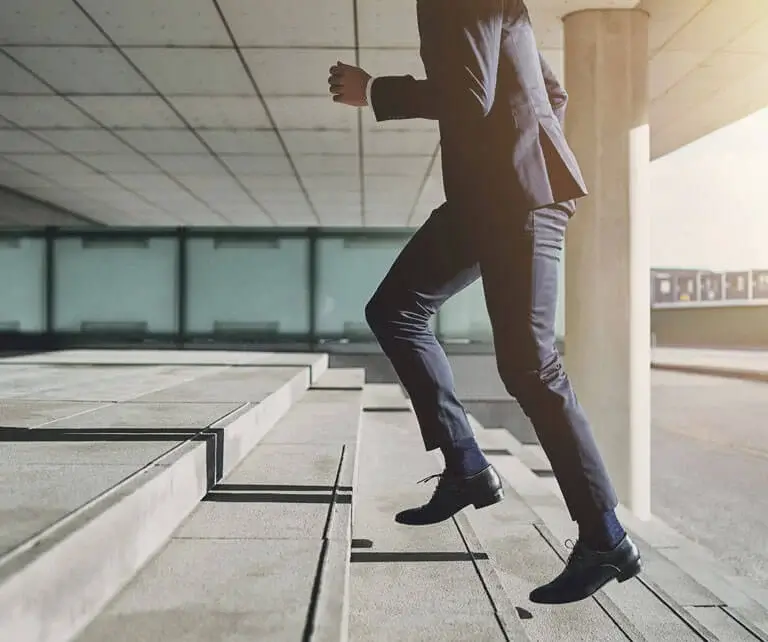Ein Geschäftsmann, der Treppen steigt, repräsentiert die Erfolgsreise mit Google Ads.