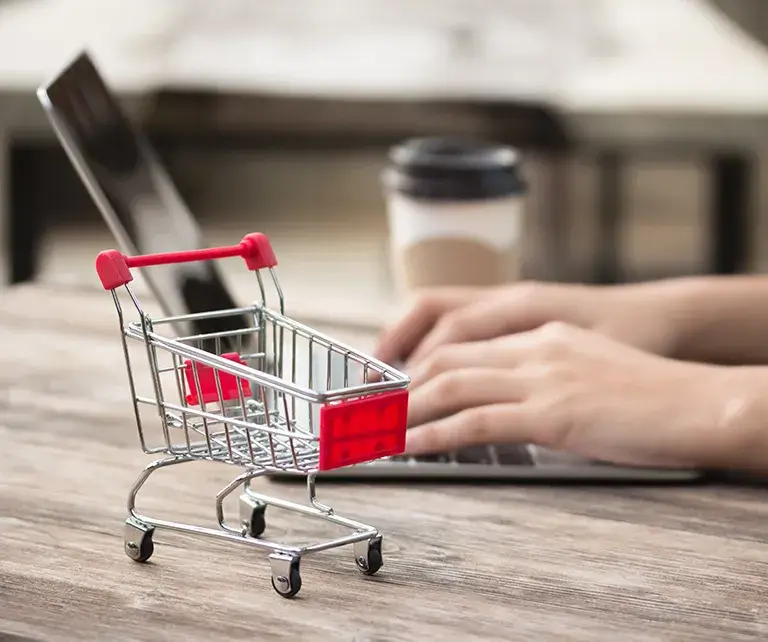 Person auf Laptop im Onlineshop stöbert. Entdecken Sie endlose Möglichkeiten!